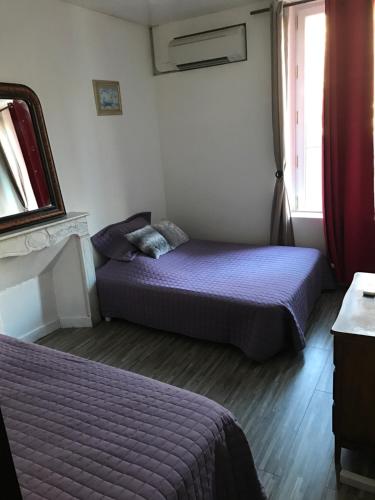 a bedroom with two beds and a window at Les 2 Alpes in Puget-Théniers