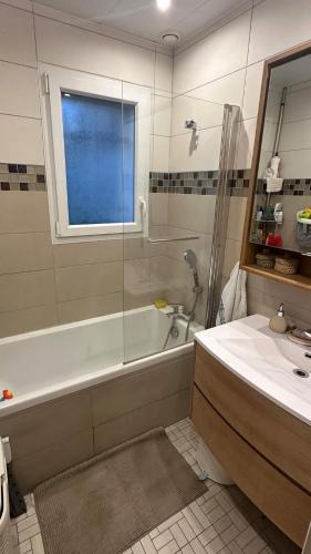 a bathroom with a shower and a tub and a sink at La caravane de Camille & Piscine in Soulaires