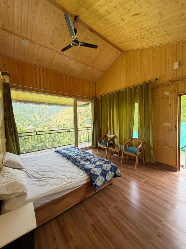 a bedroom with a bed and a ceiling fan at Kabila King Resort in Chakrāta