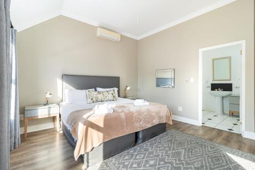 a bedroom with a large bed and a rug at Winelands Golf Lodges 12 in Stellenbosch