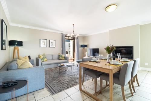 a living room with a table and a couch at Winelands Golf Lodges 12 in Stellenbosch