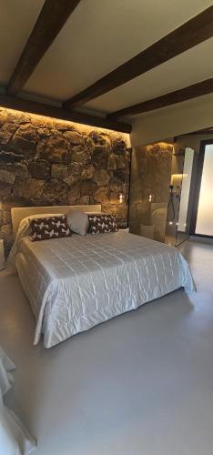 a bed in a room with a stone wall at Residenza Grazia sul mare in Abbiadori
