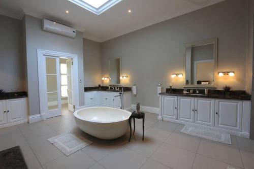 a large bathroom with a tub and a sink at Private Manor Estate Fly Fishing Sleeps 18 in Dullstroom