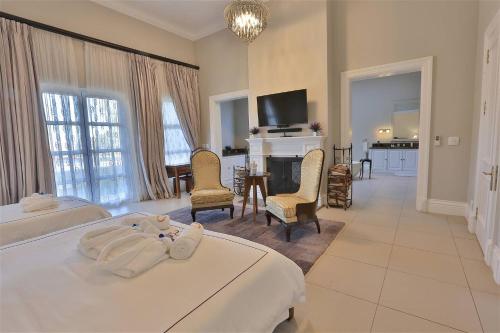 a bedroom with two beds and a living room at Private Manor Estate Fly Fishing Sleeps 18 in Dullstroom