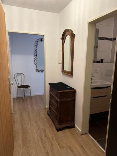 a bathroom with a wooden dresser and a mirror at Fewo Strandweg Überlingen in Überlingen
