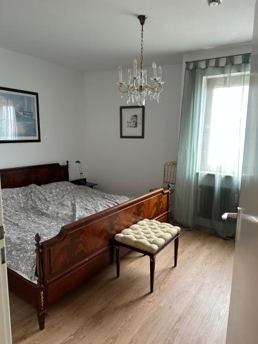 a bedroom with a large bed and a chandelier at Fewo Strandweg Überlingen in Überlingen