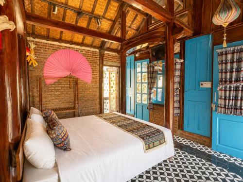 a bedroom with a bed with a pink umbrella at Wooden chill house in Hoi An