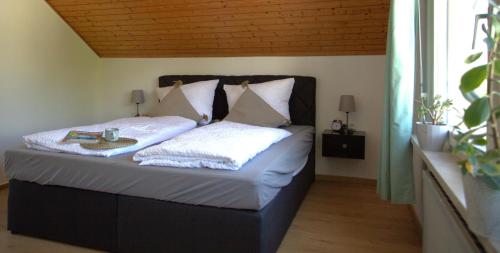 a bedroom with a bed with white sheets and pillows at Rose in Überlingen