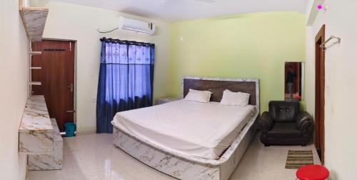 a bedroom with a bed and a chair at Alliswell in Patna