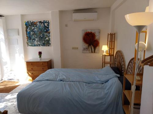 a bedroom with a bed with a blue comforter at Casa Papaver Casita in Coín