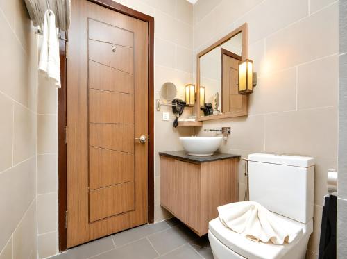 a bathroom with a toilet and a sink at Norodom Clover Hotel in Phnom Penh