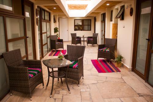 a patio with wicker chairs and a table on a patio at Hostal Anpaymi Atacama in San Pedro de Atacama