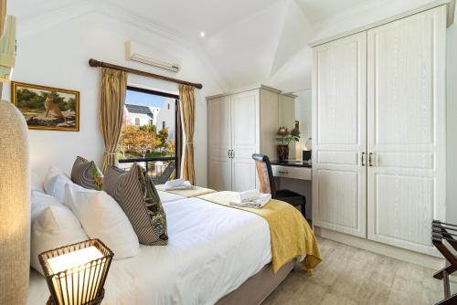 a bedroom with a bed and a desk in a room at Winelands Golf Lodges 14 in Stellenbosch