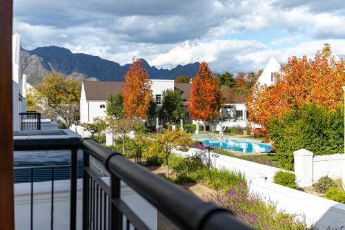 a balcony with a view of a pool and mountains at Winelands Golf Lodges 14 in Stellenbosch