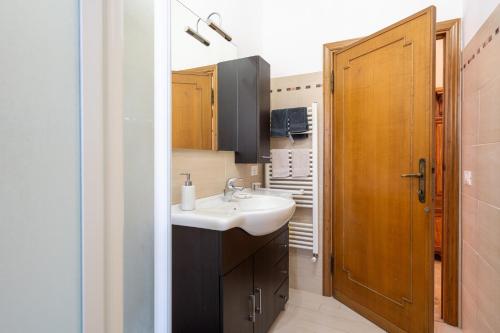 a bathroom with a sink and a wooden door at Casa Corniolo Near Arezzo in Monte San Savino