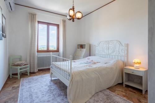 a white bedroom with a bed and a window at Casa Corniolo Near Arezzo in Monte San Savino