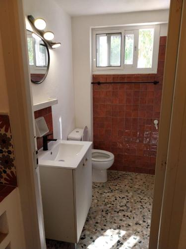 a bathroom with a white sink and a toilet at Casa Papaver Casita in Coín