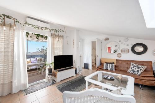 a living room with a couch and a television at Casa D’Amelia in Ojén