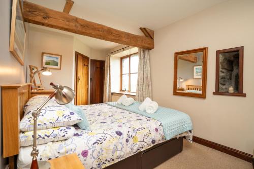 a bedroom with a bed and a mirror at Ystumgwern Luxury Barn Conversions in Dyffryn