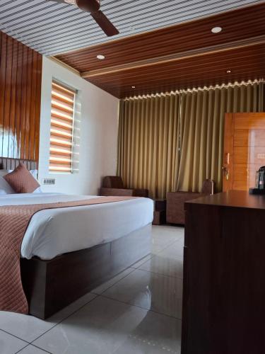 a bedroom with a bed and a desk in a room at Merjin's Paraiso in Vagamon