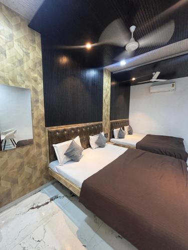 two beds in a room with a ceiling at Meghdoot New Resort in Matheran