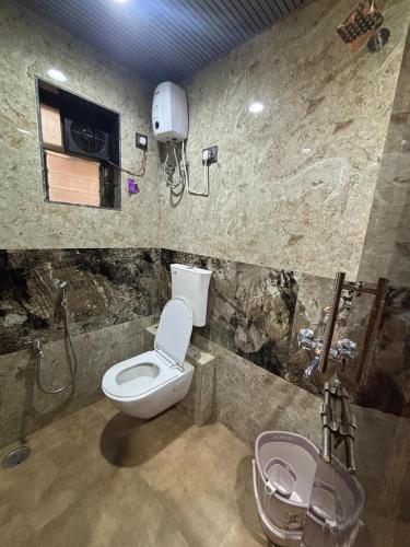 a bathroom with a toilet and a sink at Meghdoot New Resort in Matheran