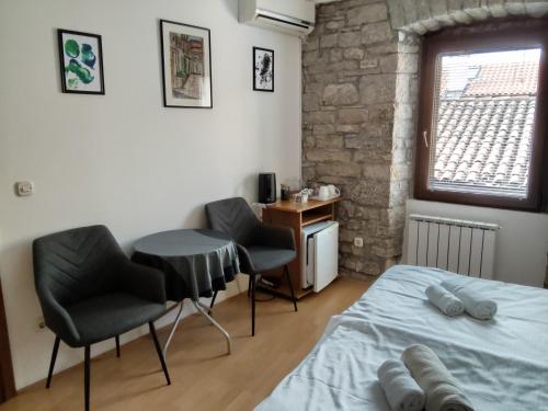 a bedroom with a bed and two chairs and a table at Rooms Svalina in Grožnjan
