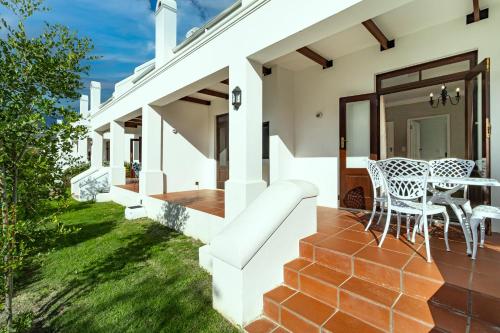 a patio with a table and chairs on a house at Winelands Golf Lodges 15 in Stellenbosch