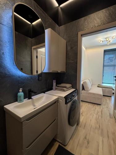 a bathroom with a sink and a washing machine at Apartament Ania Nysa Centrum z bezpłatnym parkingiem in Nysa