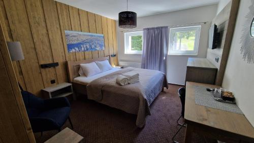 a hotel room with a bed and a chair at Pension Renata in Harrachov