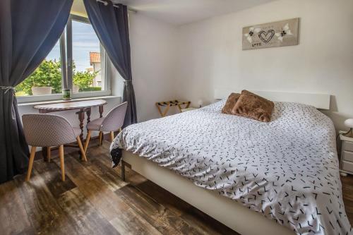 a bedroom with a bed and a table and a window at Chambre d'hotes 2 à Bramefort in Champsac