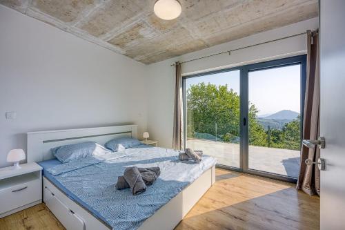 a bedroom with a bed and a large window at Villa Nono in Motovun