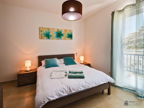 a bedroom with a bed and a window at Hillock Residence Apartments in Marsalforn