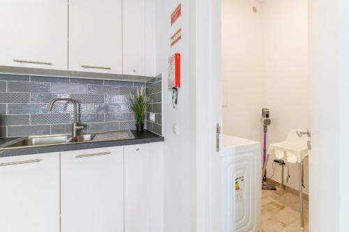 a kitchen with white cabinets and a sink at Casa Formosa in Odeceixe