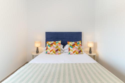 a bedroom with a large bed with two lamps at Casa Formosa in Odeceixe
