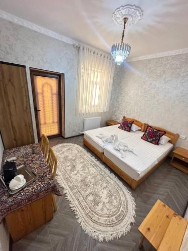 a bedroom with two beds and a chandelier at LAYALI boutique TERRACE & Café in Bukhara