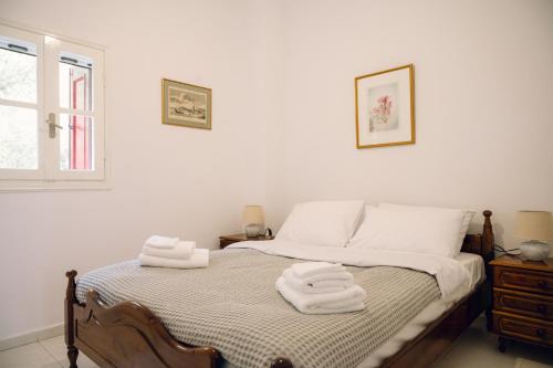 a bedroom with a bed with towels on it at Emporios 1930, Seafront stone house in Emporeiós