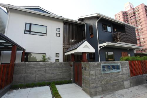 a house with a stone retaining wall in front of it at Toutsu Gyoen in Donggang