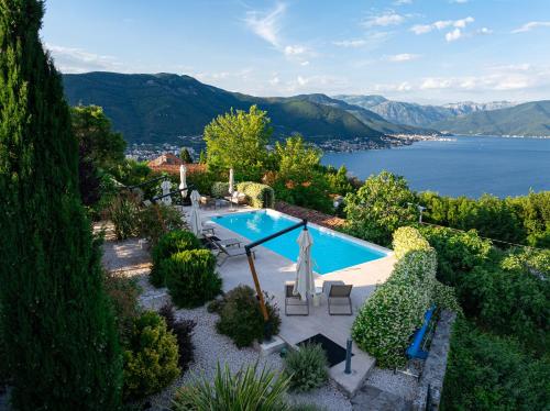 an outdoor swimming pool with a view of the water at Villa Stari Mlin in Luštica