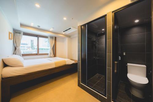 a small bedroom with a bed and a shower at Seoul101 Jongno in Seoul