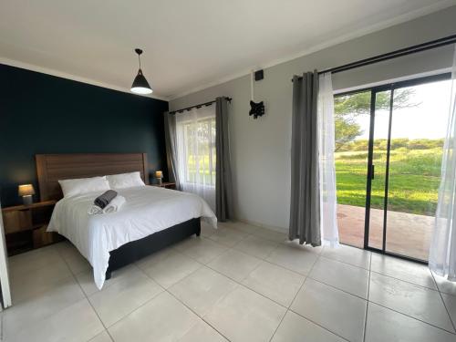 a bedroom with a bed and a large window at ValView Guest Lodge in Thabazimbi