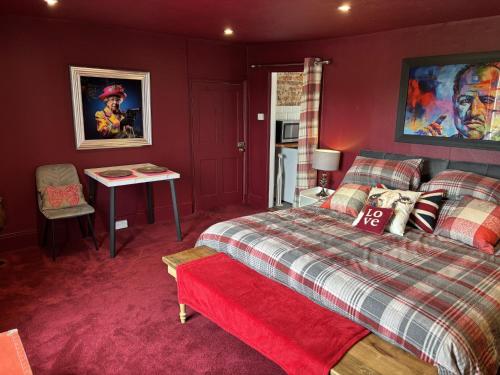 a bedroom with a bed and a table in it at The Flat The Plough in Birdbrook