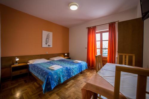 a bedroom with a bed and a table and a window at Studio Apartman Rovinj in Rovinj