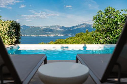 a pool with a view of the water and mountains at Villa Stari Mlin in Luštica