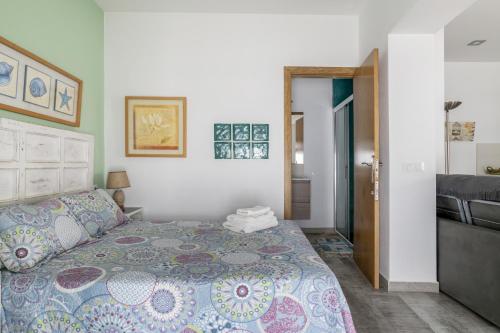 a bedroom with a bed and a door to a bathroom at Girasol in Vejer de la Frontera