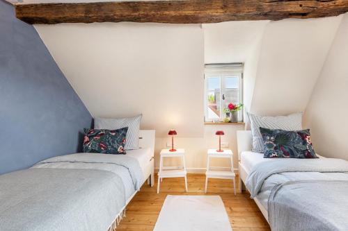 two twin beds in a room with a window at Ferienhaus Gerbertor am Goldbach in Dörzbach