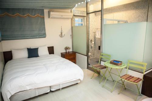 台東市的住宿－星光民宿，一间卧室配有一张床和两把椅子,并提供淋浴。