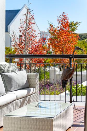 a bird statue on a balcony with a couch at Winelands Golf Lodges 24 in Stellenbosch