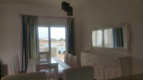 a room with a mirror and a dresser and a window at Twin Lagoon Apartment at White Villas El Gouna in Hurghada
