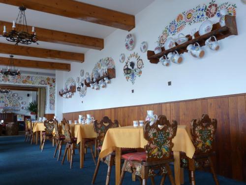 a dining room with tables and chairs and plates on the wall at Erika penzión in Vysoké Tatry